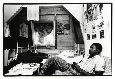 107730 Afbeelding van een Ghanese vluchteling op zijn kamer in een opvanghuis te Utrecht.